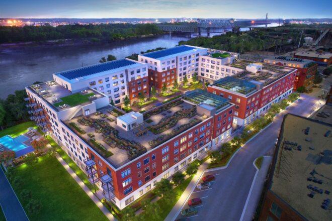 aerial view of large red and white building with green roof
