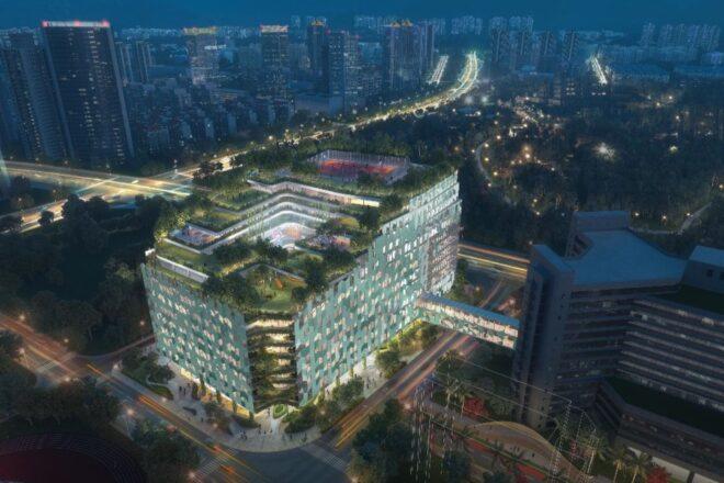 aerial rendering of glass hospital building with a green roof at night