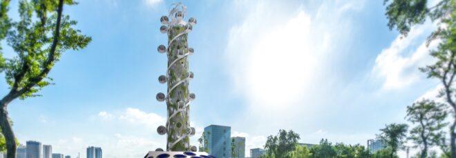 a rendering of a tall, spiral tower. several ball-shaped capsules spiral up and down the building. toward the base of the tower is a rooftop with blue circles on it.