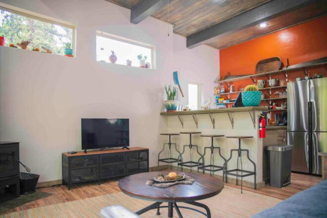 modern interior with bar, small TV, and round wood table