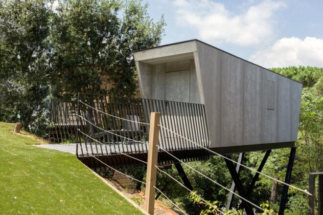 small concrete home on stilts