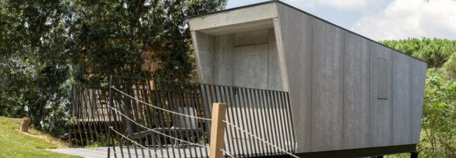 small concrete home on stilts