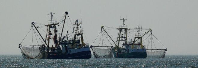 two large fishing boats on ocean waters