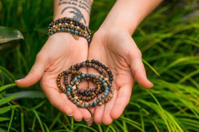 person holding beaded bracelets