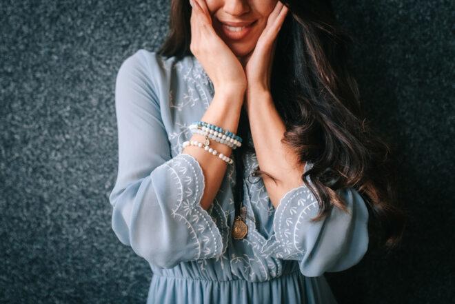 person in blue dress wearing blue beaded bracelets