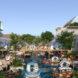 rendering of boats on canal near buildings with steeply pitched roofs