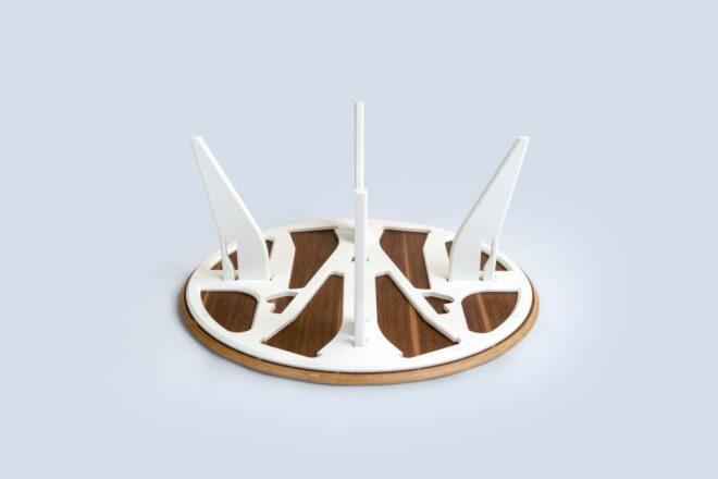 a flat white and wood-colored circle with construction pieces sticking out