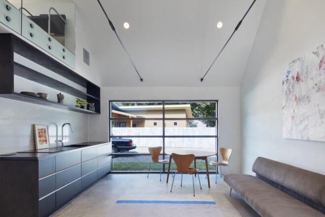 gray sofa across from small kitchen space
