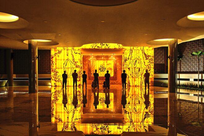 people observing glowing yellow wall