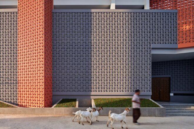 person walking past gray and red mosque