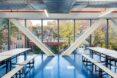 school lunchroom with picnic tables, blue floors and a wall of glass
