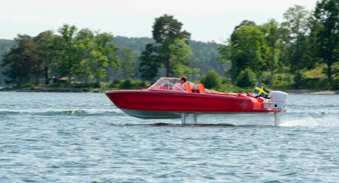 red electric boat speeding along water