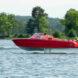 red electric boat speeding along water