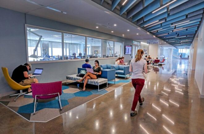 people working on computers in colorful lounge area