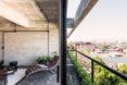 white lounge chair near wall of glass with small balcony