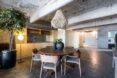 round wood table under chandelier in industrial building