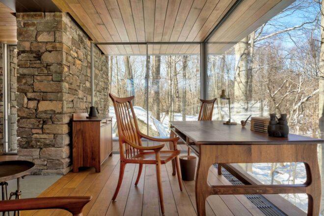 wood chair at wood desk in room with glass walls
