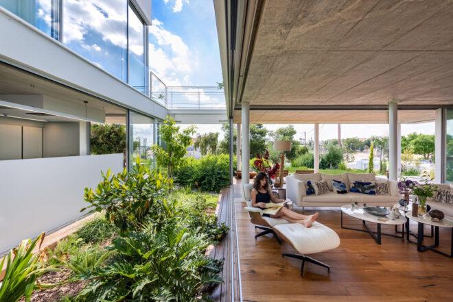 person on white lounge chair near indoor garden