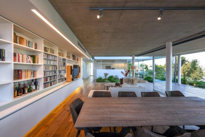wood dining table near wall of bookshelves