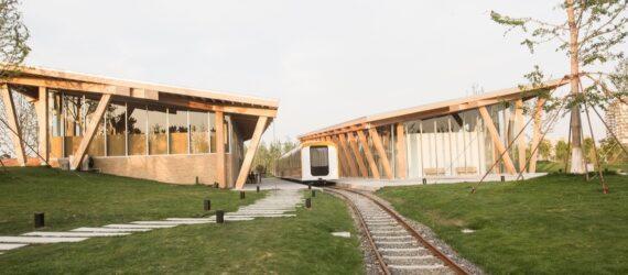 train traveling between two timber buildings