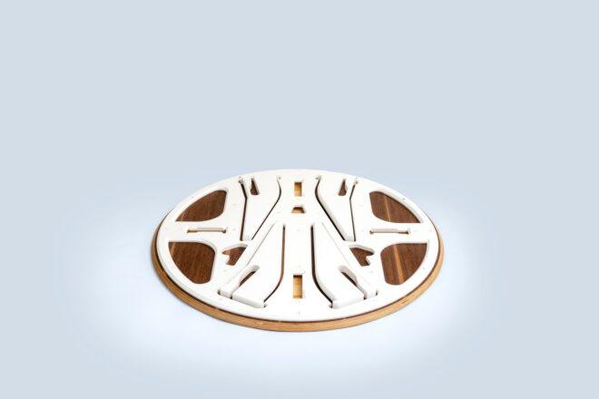 a flat white and wood-colored circle with construction pieces inlaid