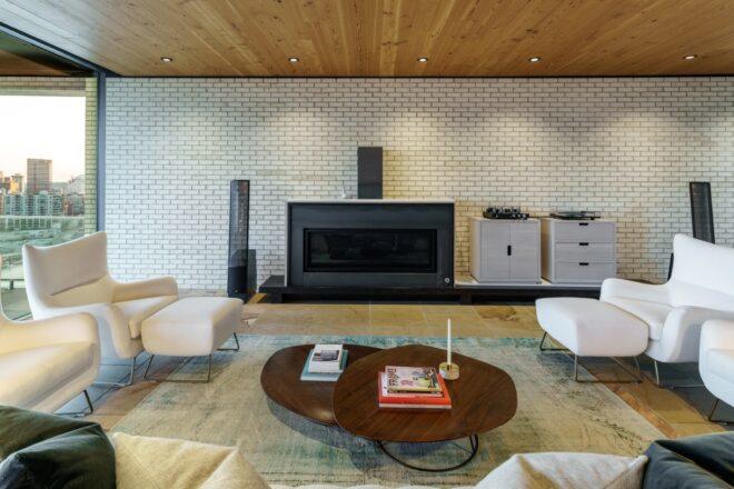 white chairs and round wood coffee table facing a black fireplace