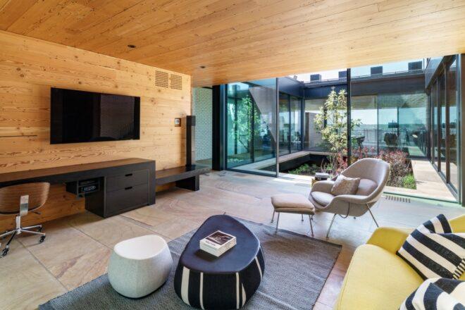 gray chair and black and white coffee table facing a wall-mounted TV