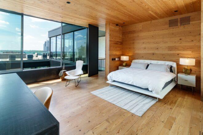 large white bed in room with wood floors, walls and ceiling