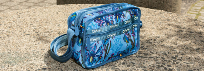 a floral patterned blue bag sits on a concrete platform.