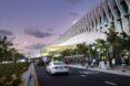 car driving past metal and glass building with several solar fins