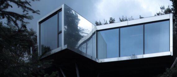 reflective metal and glass cabin on hillside