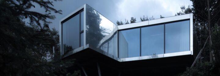 reflective metal and glass cabin on hillside