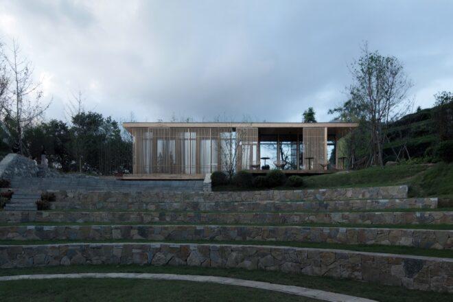 glass cabin with wood slat exterior near tea fields