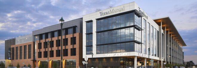 a streetview of the Texas Mutual headquarters building, made up of block-shaped volumes with red brick, glass and white and dark gray paneling for the facade.