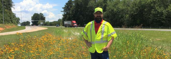 Matthew Quirey in meadow by a highway
