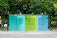 public toilet building with blue and green glass walls
