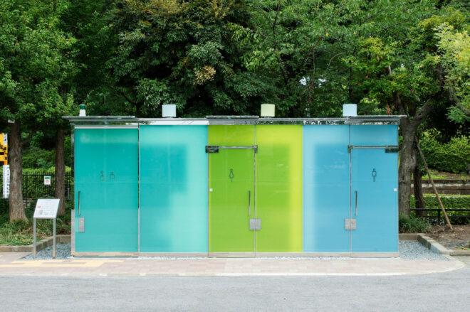 public toilet building with blue and green glass walls