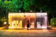 public toilet building with yellow, red and purple glass walls that are transparent with doors open