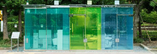 public toilet building with blue and green glass walls