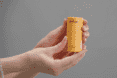 two hands holding a yellow tube of deodorant.