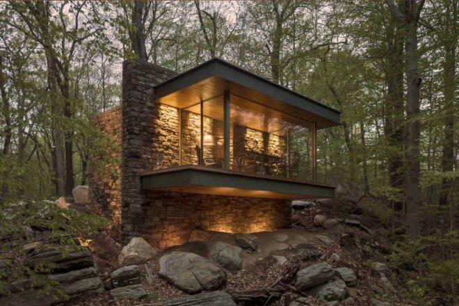 stone cabin with glass walls in a forest