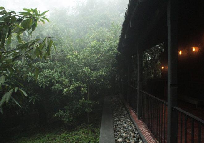 long porch of black home surrounded by trees