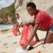 two friends picking up trash on a beach