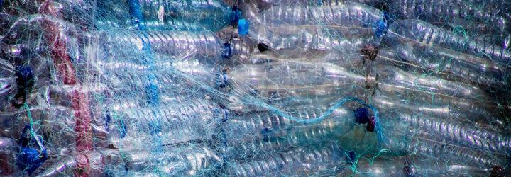 many empty plastic water bottles covered in blue netting