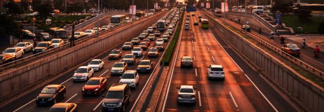 four lanes of traffic packed with cars at sunset