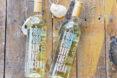 two bottles of white wine on weathered wood table