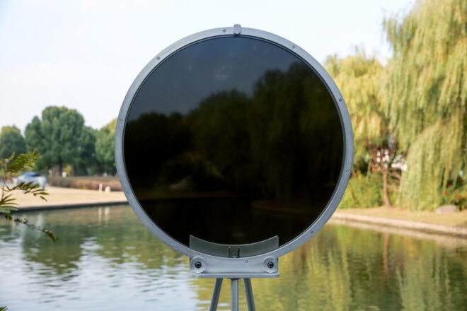 circular smog tracker device near lake with center turning dark