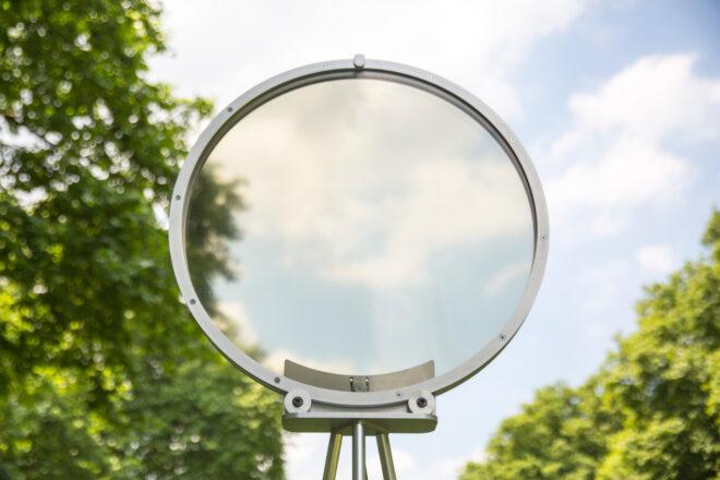 circular smog tracker device near lake with transparent center