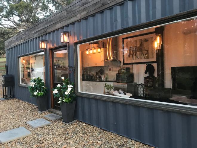 black corrugated metal tiny home with large windows
