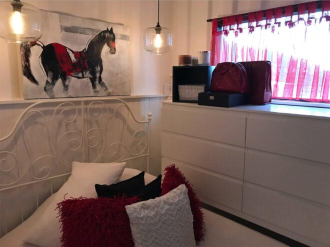 Red and white bedroom with horse art on wall